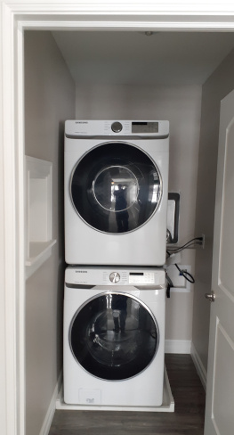 laundry room with front load washer and steam dryer.